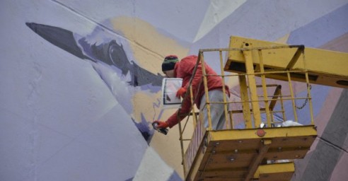 Львовянин рисует мурал в Харькове